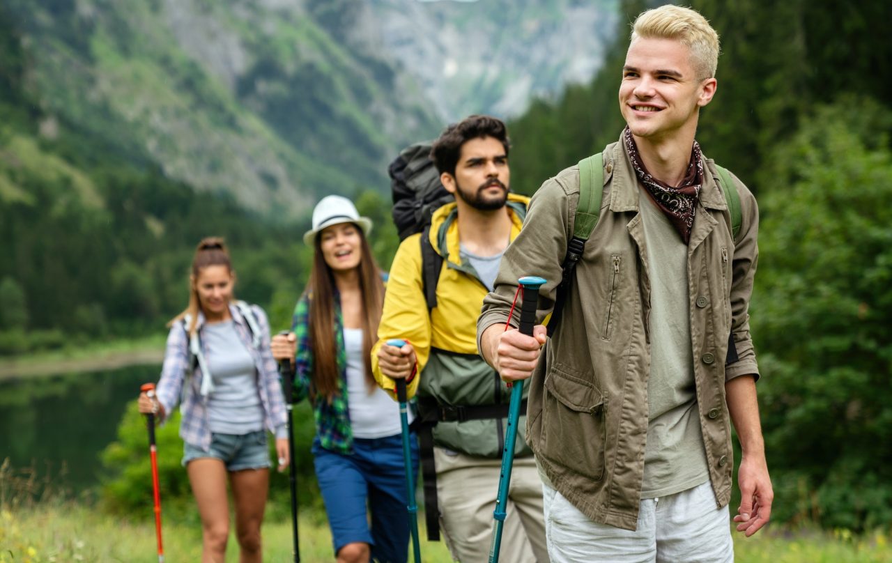 Group Of Friends With Backpacks Doing Trekking Excursion On Mountain