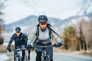 Group Of Mountain Bikers Riding On Road Outdoors In Winter outdoor clothing